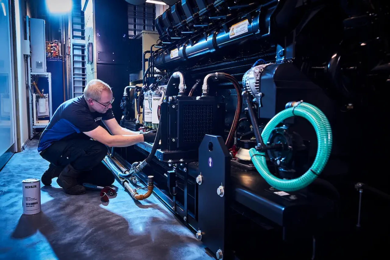 service technieker onderhoudt noodstroomgenerator in datacenter